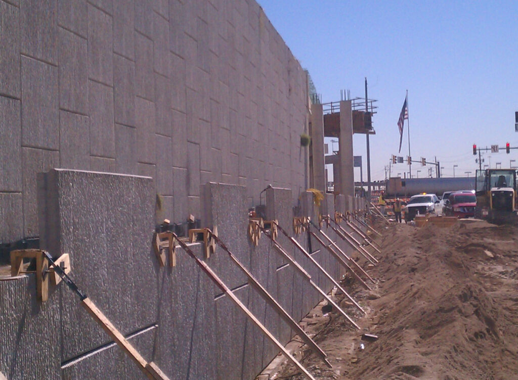 Under construction MSE wall in front of completed MSE wall