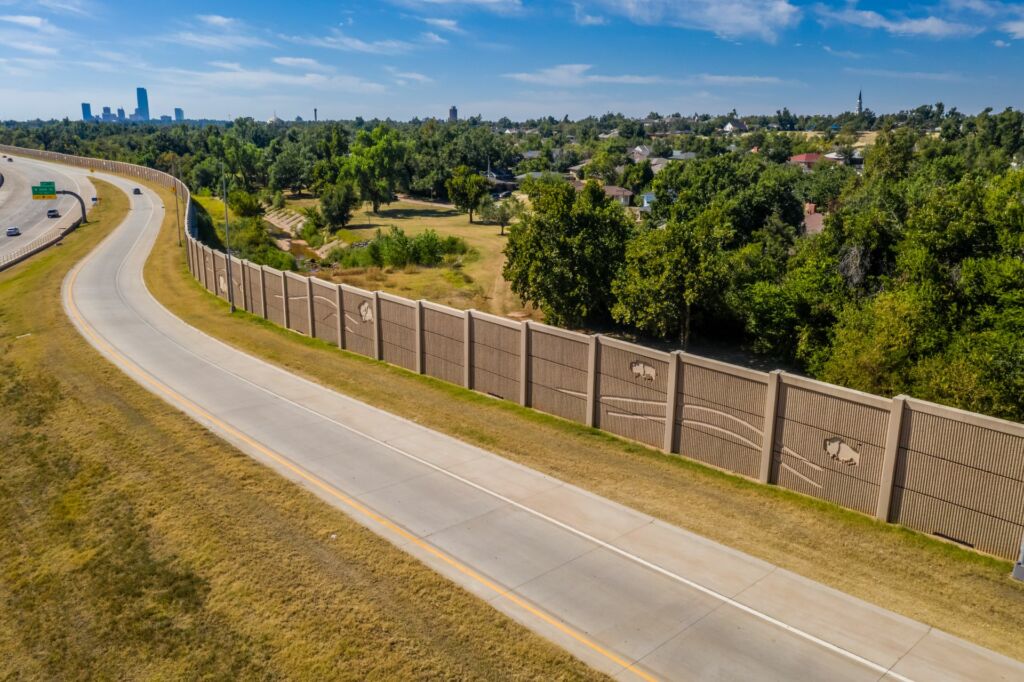 Post and panel sound wall with fractured fin finish featuring bison murals