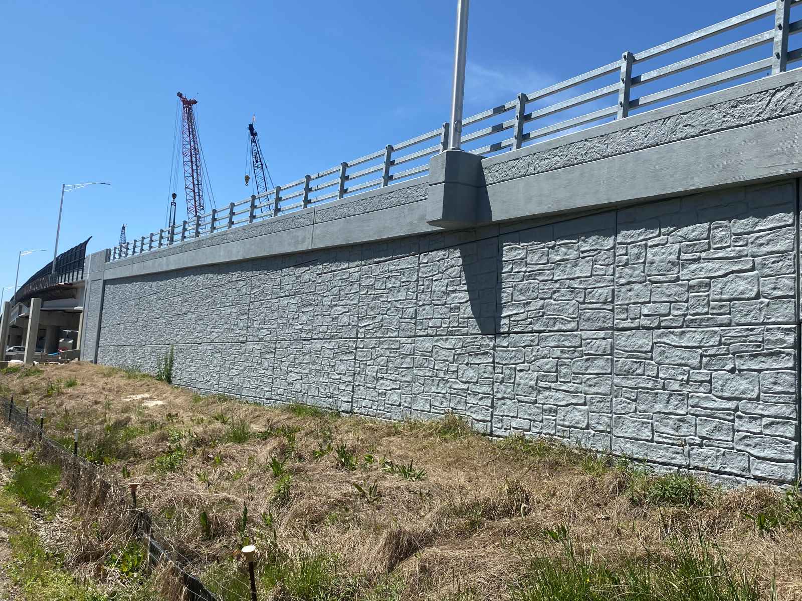 15F7C0BF-7B91-4CE2-B680-F251F7747CF1 T-Wall retaining wall with crane in background